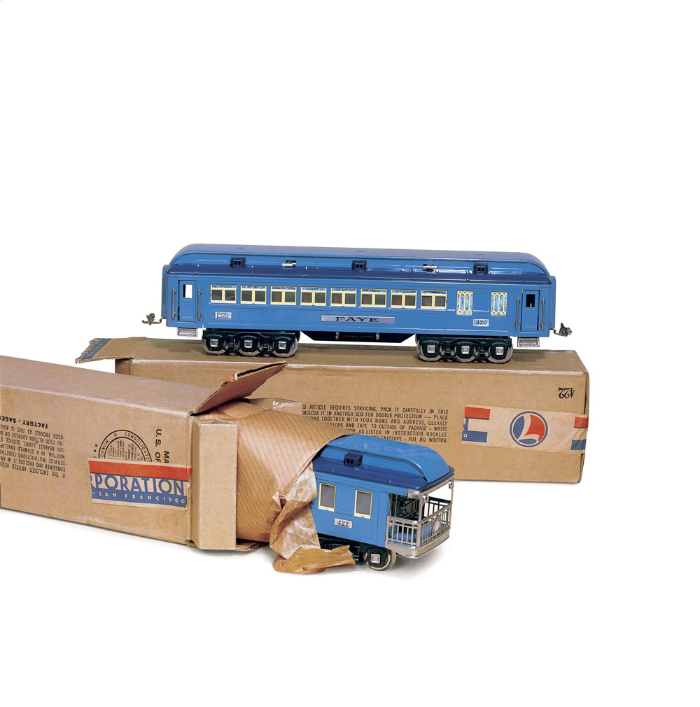 old blue toy trains next to cardboard boxes