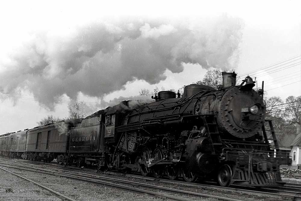 Smoking Georgia Railroad steam locomotive with passenger train