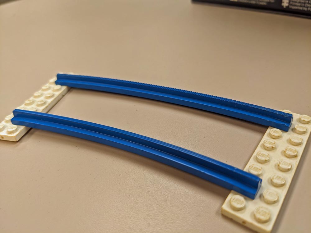 Blue plastic rails on white LEGO bricks