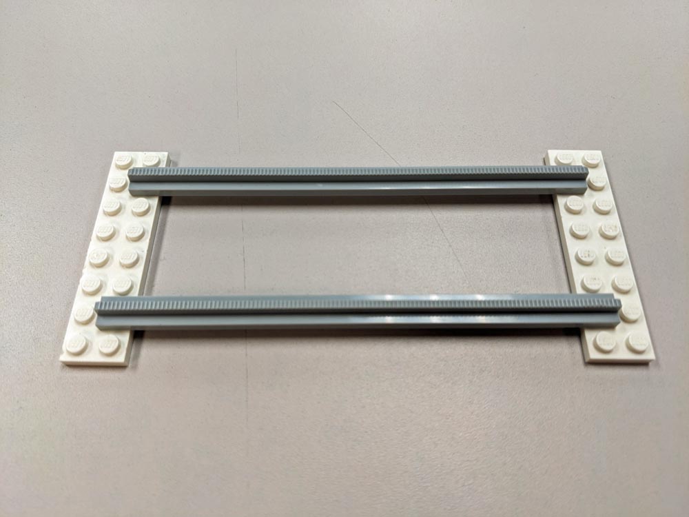 Gray plastic rails on white LEGO bricks