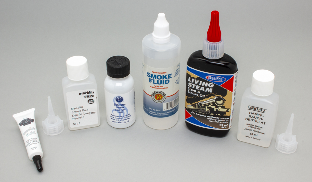 Color photo of six smoke fluid bottles on light gray background.