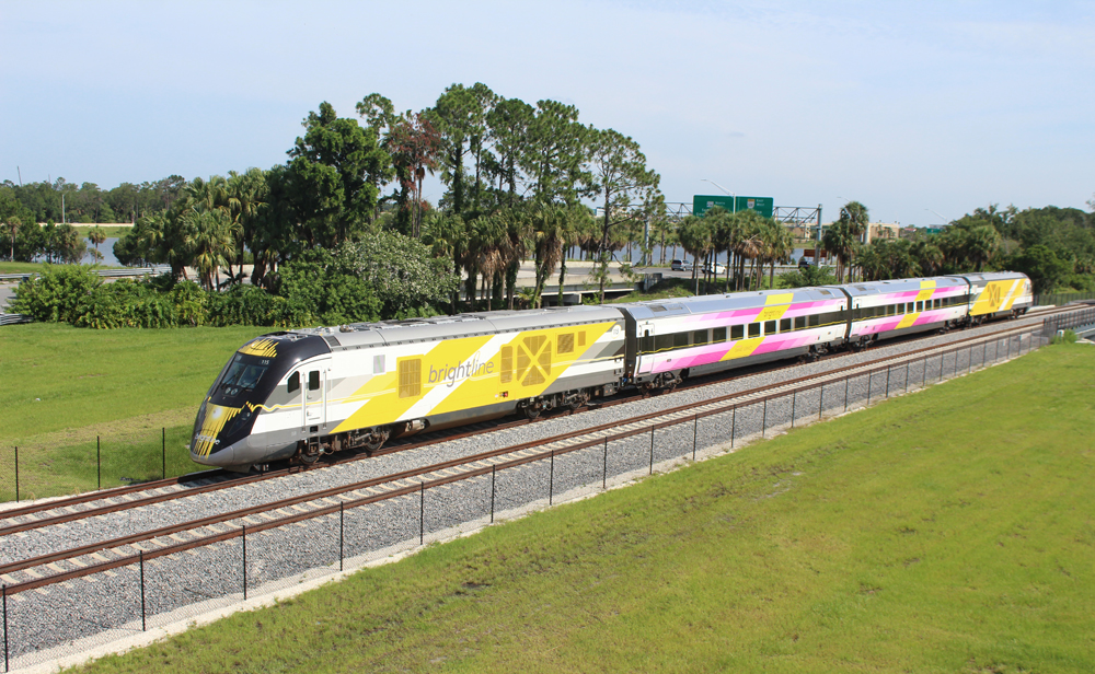 White, yellow, and pink high-speed train set. Brightline Orlando to launch service Sept. 22.