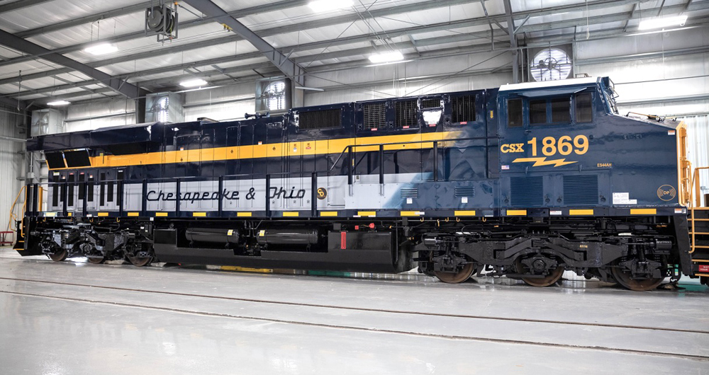 Diesel with CSX paint on cab and C&O passenger paint scheme on long hood inside shop building