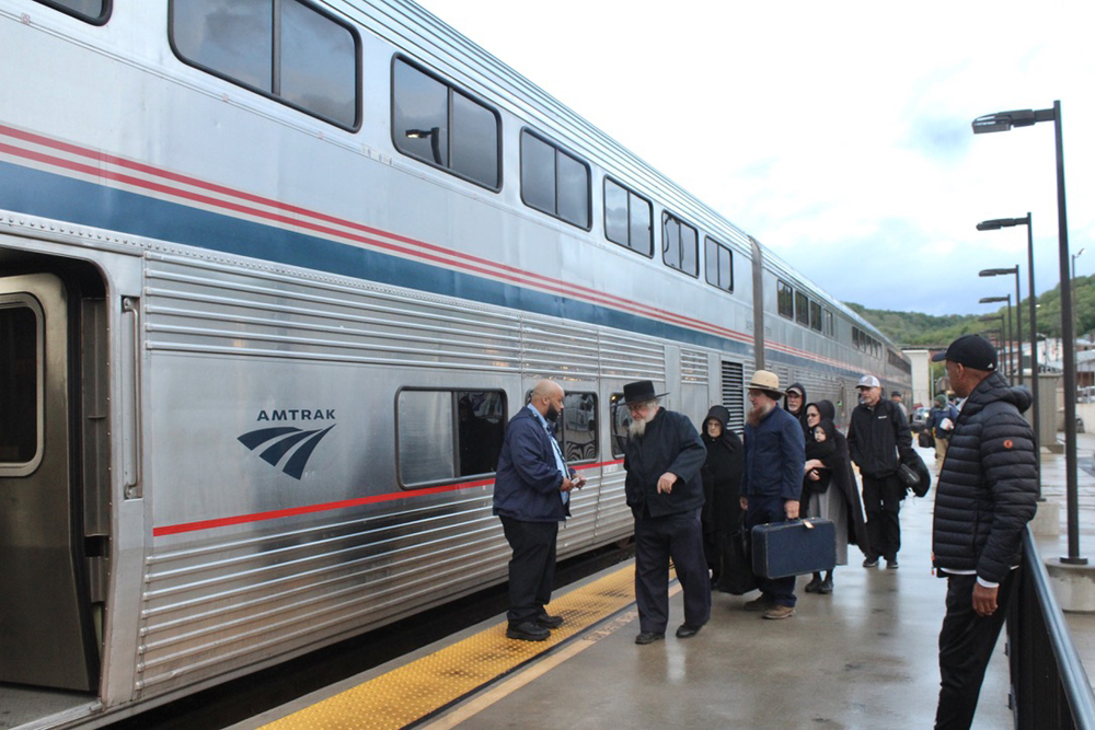 People boarding bilevel passenger car.