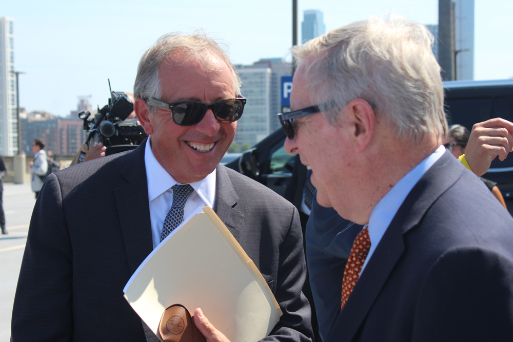 Two mean speaking with TV cameras in the background