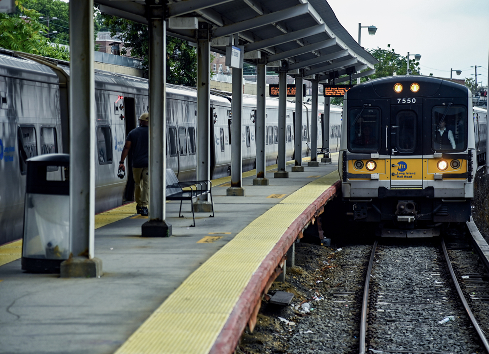 Electric multiple-unit train arrives at curving station platform.