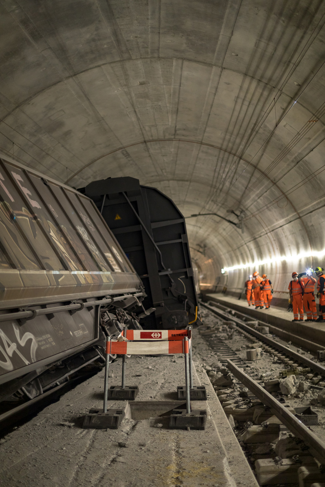 Derailed cars and workmen inside tunnel
