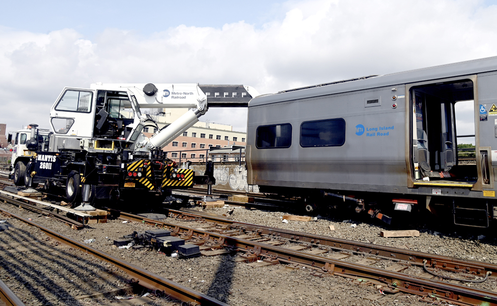 Crane lifts damaged commuter EMU car after derailment