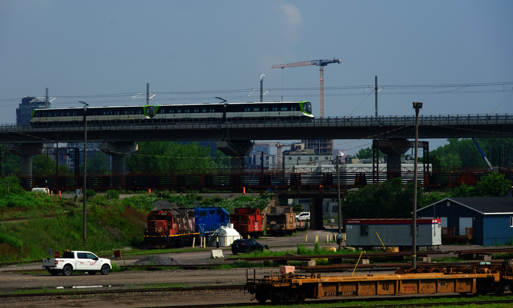 Light rail train on bridge over freight yard