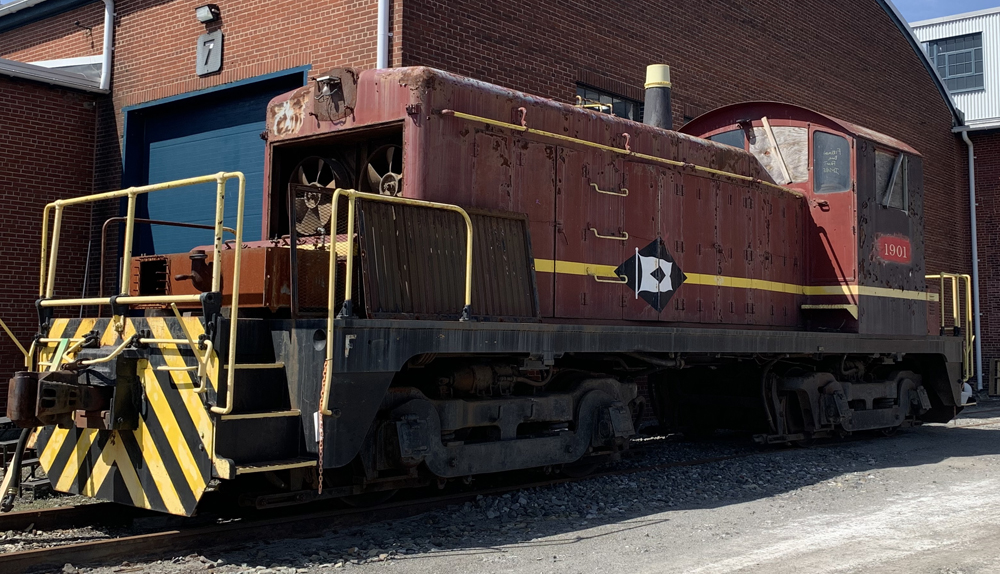 Dark red end-cab switcher in need of repairs