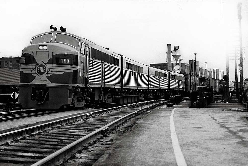 Multiple diesel Erie Railroad locomotives with freight train in city