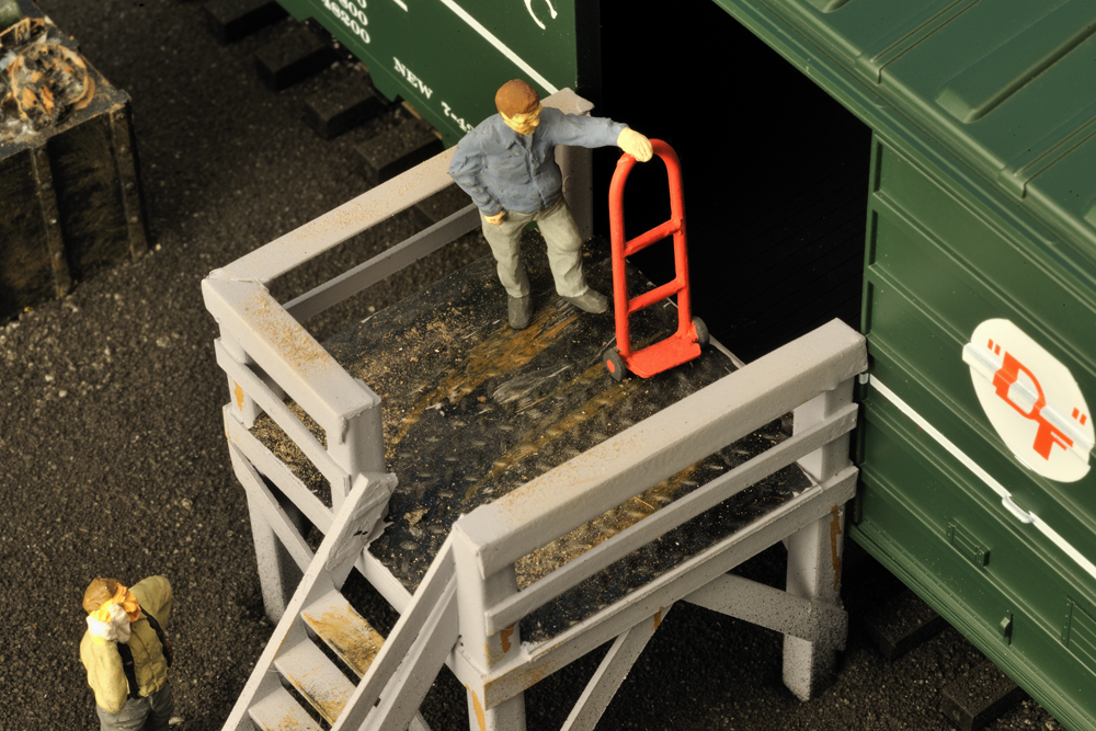 weathered and painted unloading platform with green boxcar