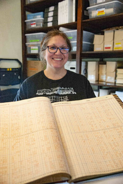 Woman holding historic railroad record.