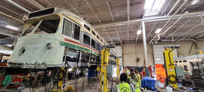 PCC trolley on jacks in shop during restoration. PCC cars return to the streets of Philadelphia.
