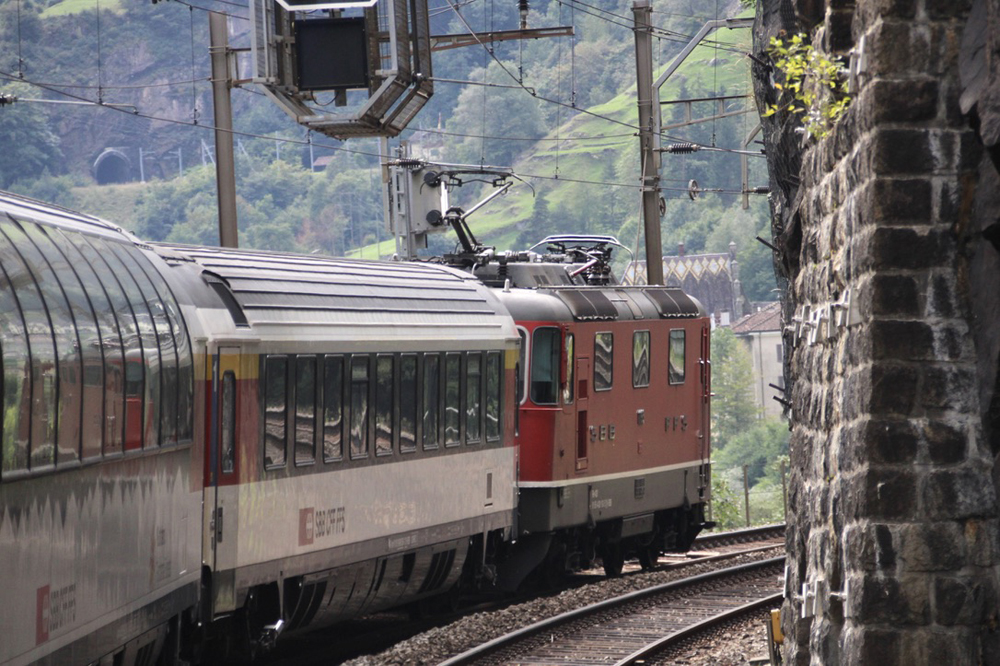 Red electric locomotive and cars as seen from onboard train