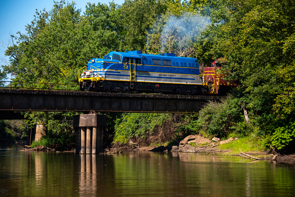 Blue and gray locomotive on bridge