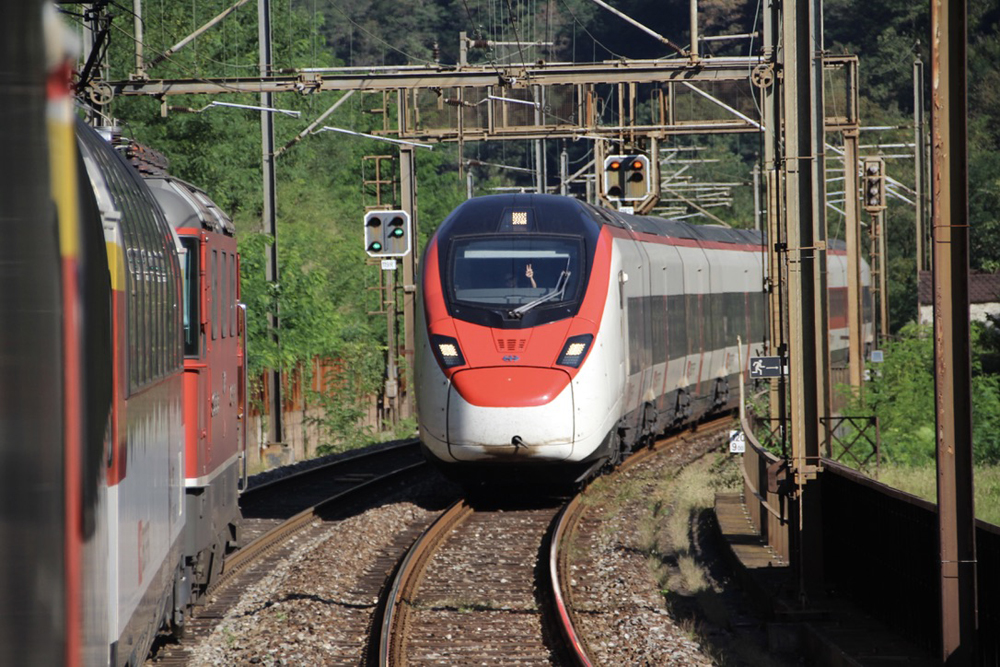 Passenger trains meet on electrified route in view from onboard