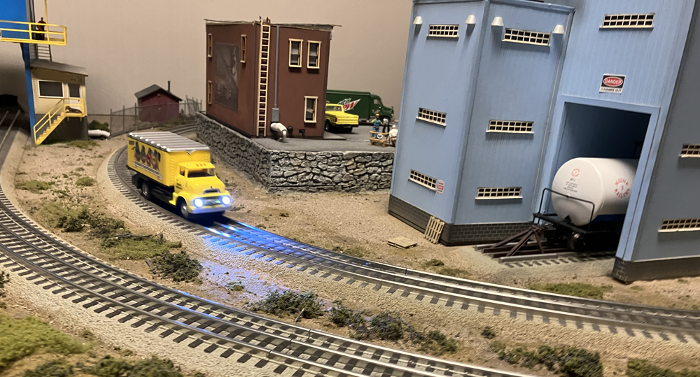 yellow truck with headlights on track