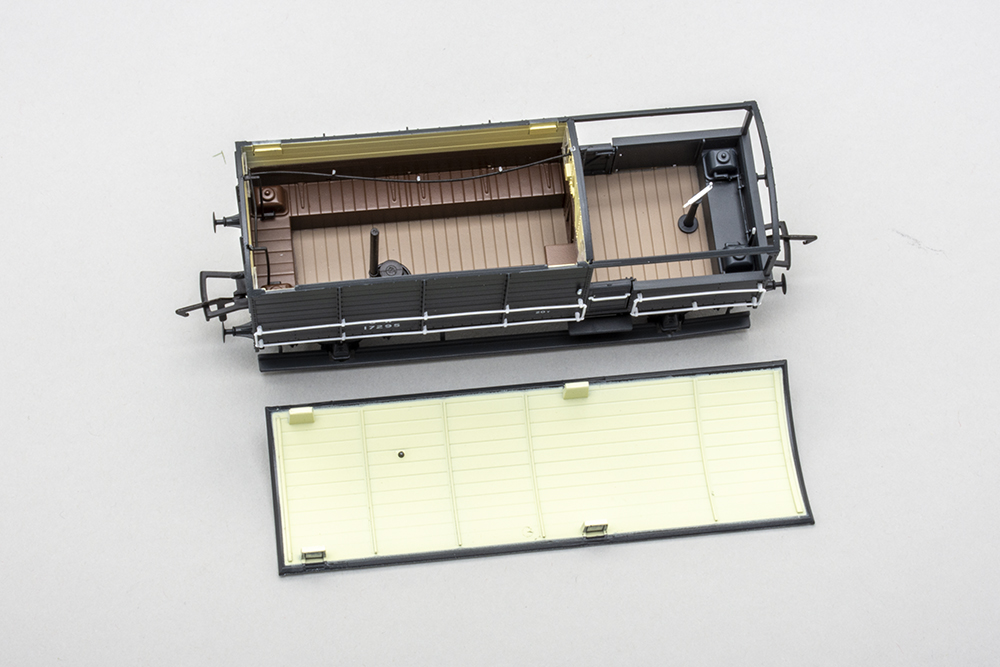Rapido UK brake van: Model of a British crew wagon with white roof removed revealing brown benches and a black stove.