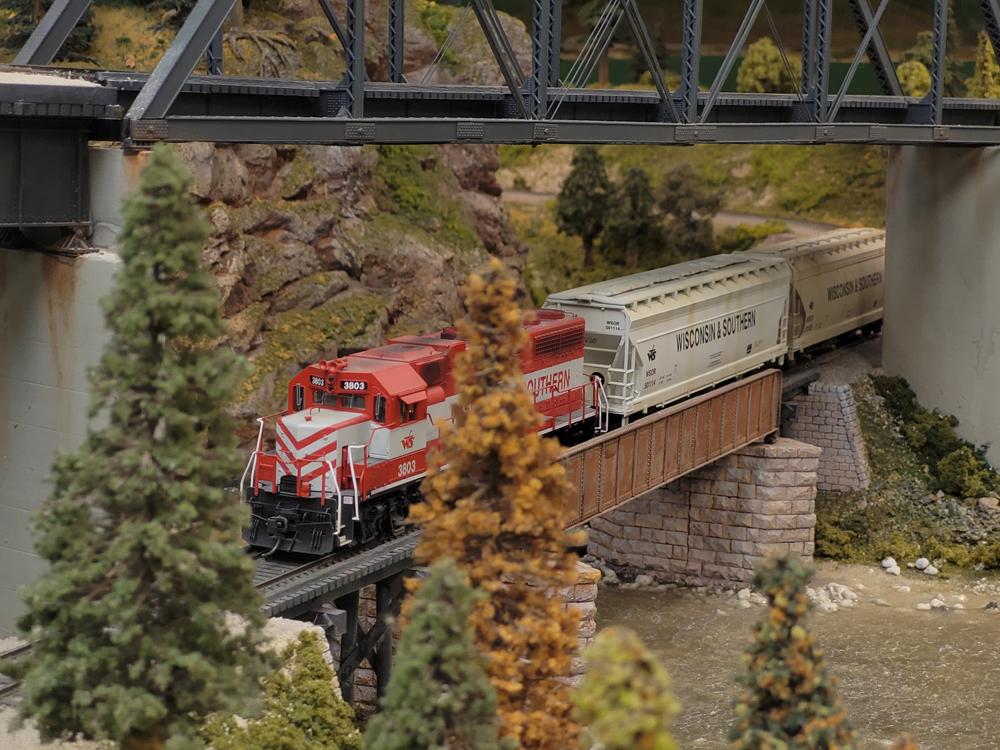 A model train passes on a bridge on a model railroad layout