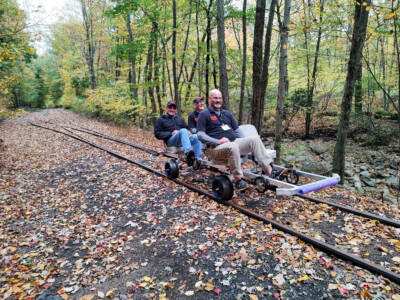 Three men peddling a rail bike.