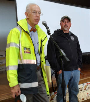 Two men talking into a microphone