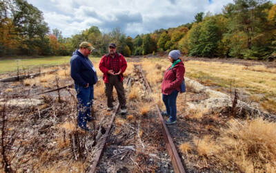 Three men and a lady standing on the site of an old engine shed.