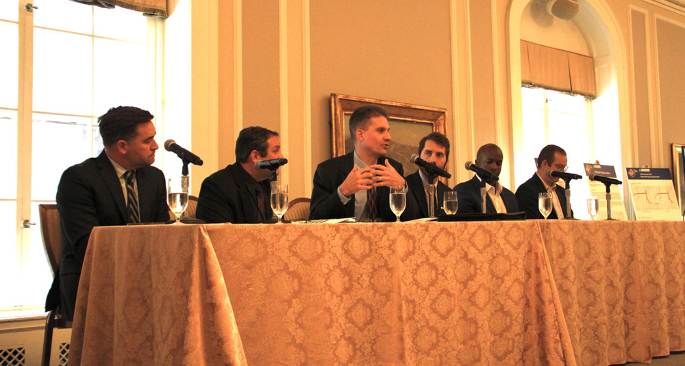 SIx men at table in poorly lit room