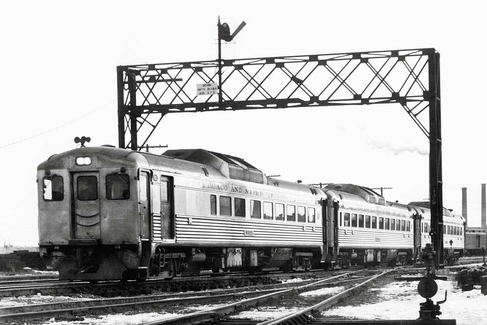 Self-propelled passenger rail cars under signal bridge