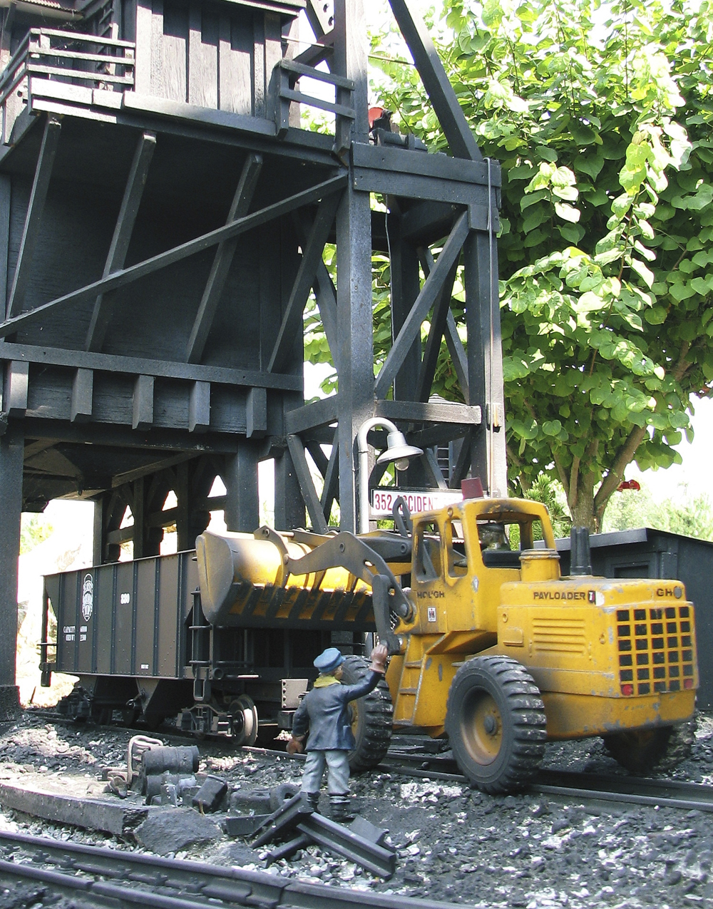 model figure near dump truck on garden railway