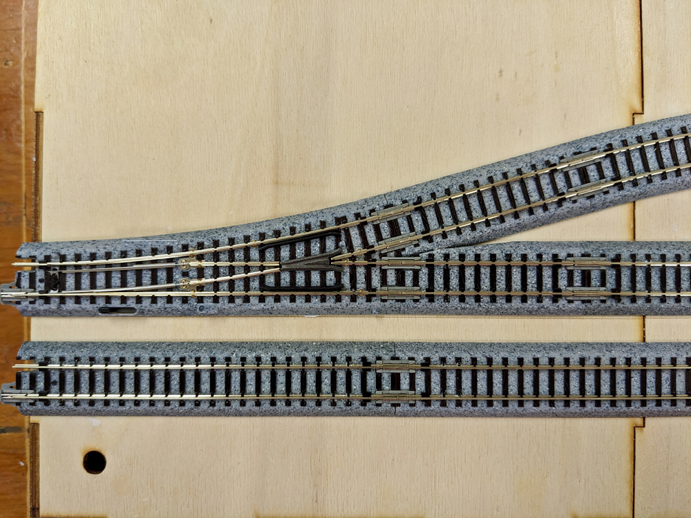 Picture of N scale turnout with gray roadbed on wood module