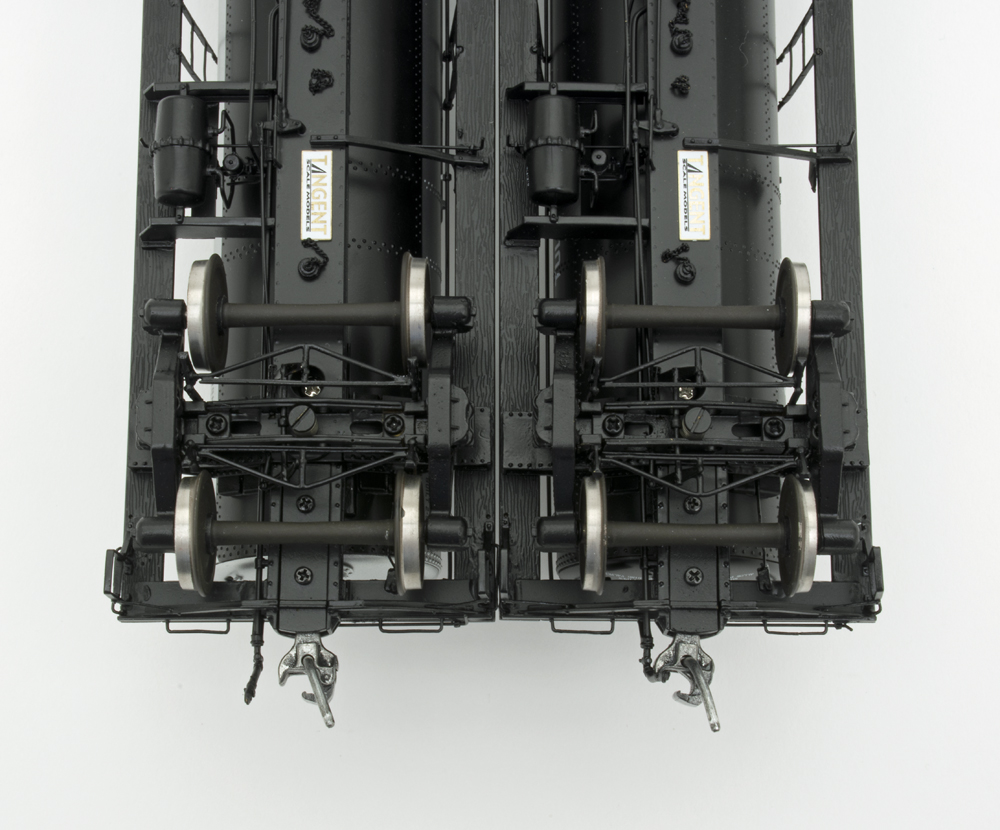 Underbody photo of O scale models showing details on freight car trucks.