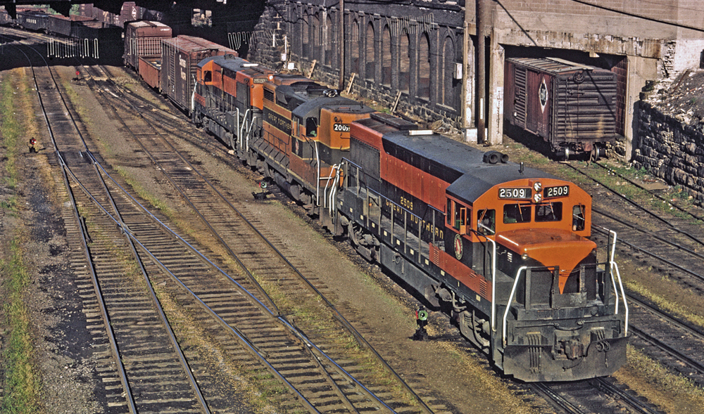 Orange and green locomotive on track