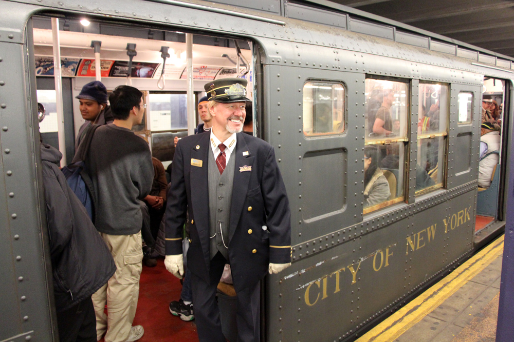 man dressed as train conductor stand between train and platform