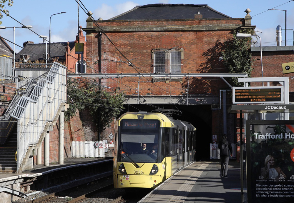 Yellow light rail train stops at station