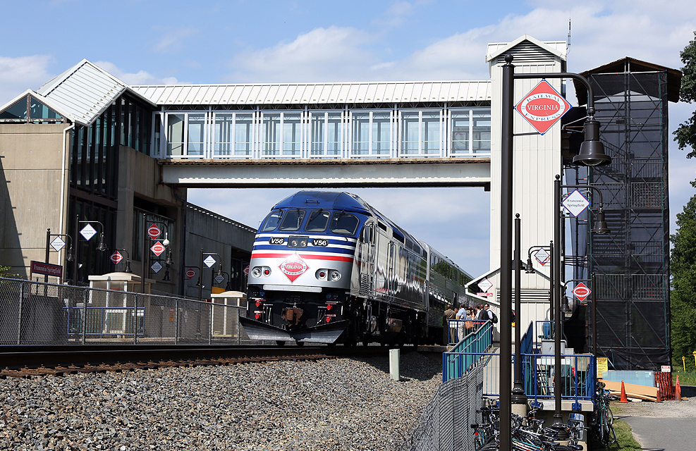 Commuter train at station with bridge connecting platforms on each side of tracks