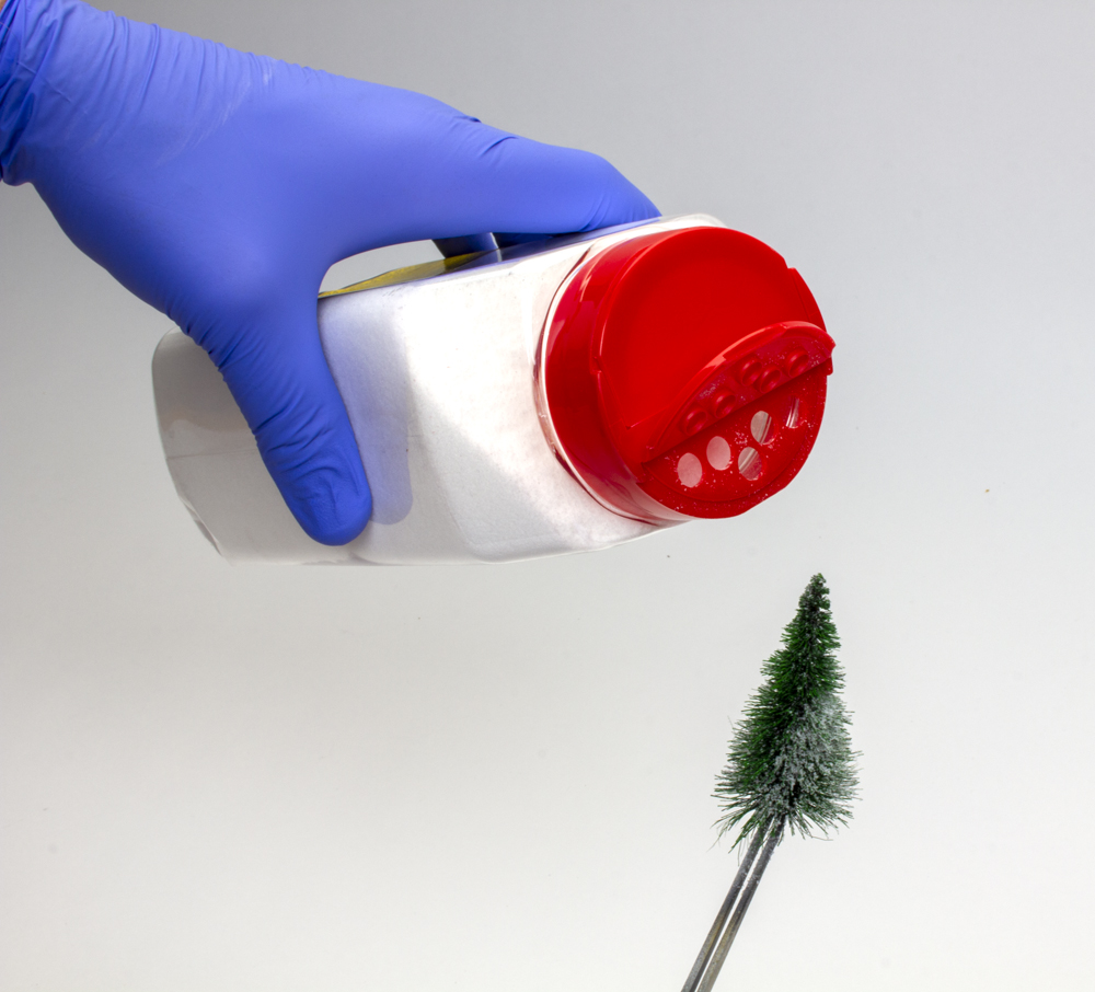 container of fake snow and model tree