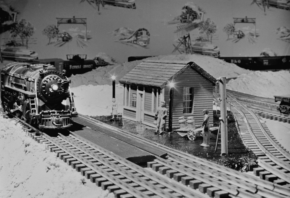 black and white photo of model train and station