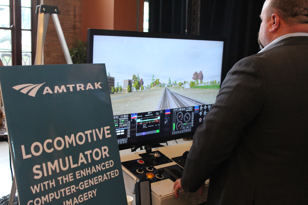 Man at computer screen showing view from front of locomotive