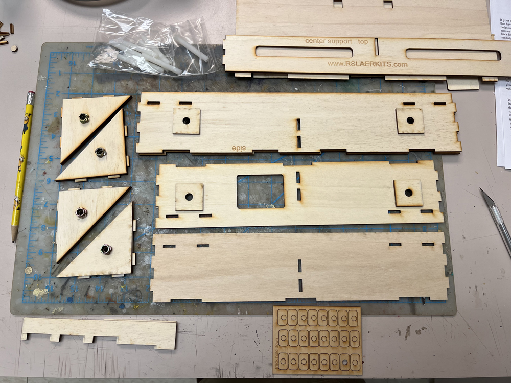 assorted wood rectangles and triangles arranged by size resting on tan workbench top.