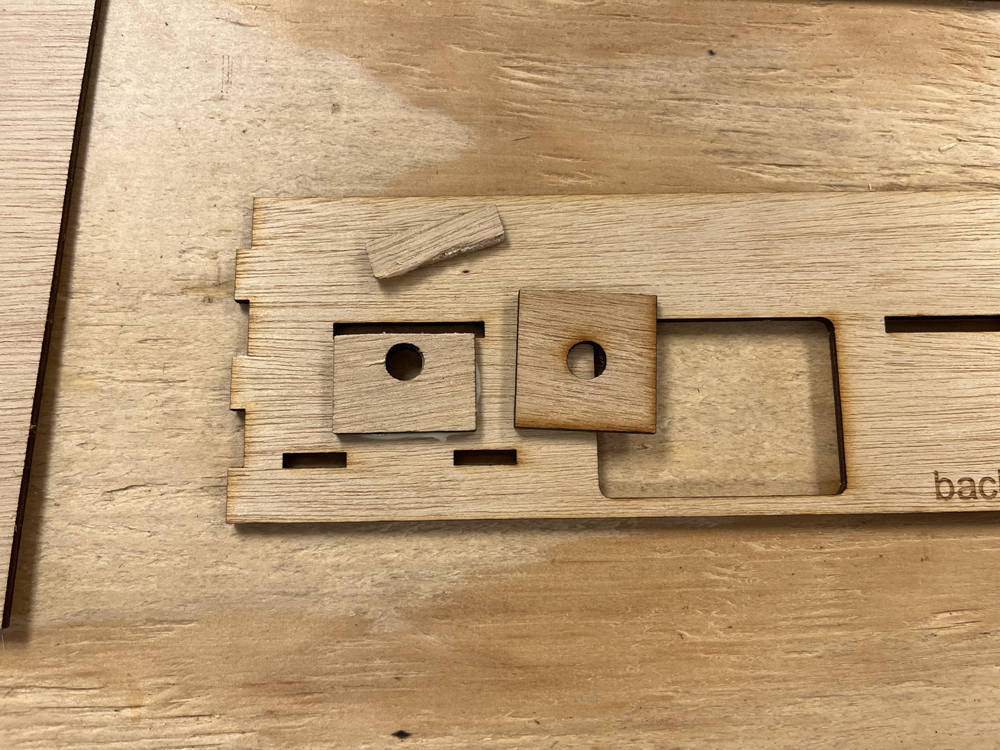 Dark brown bare wood rectangles with two small wood squares with round holes in center.