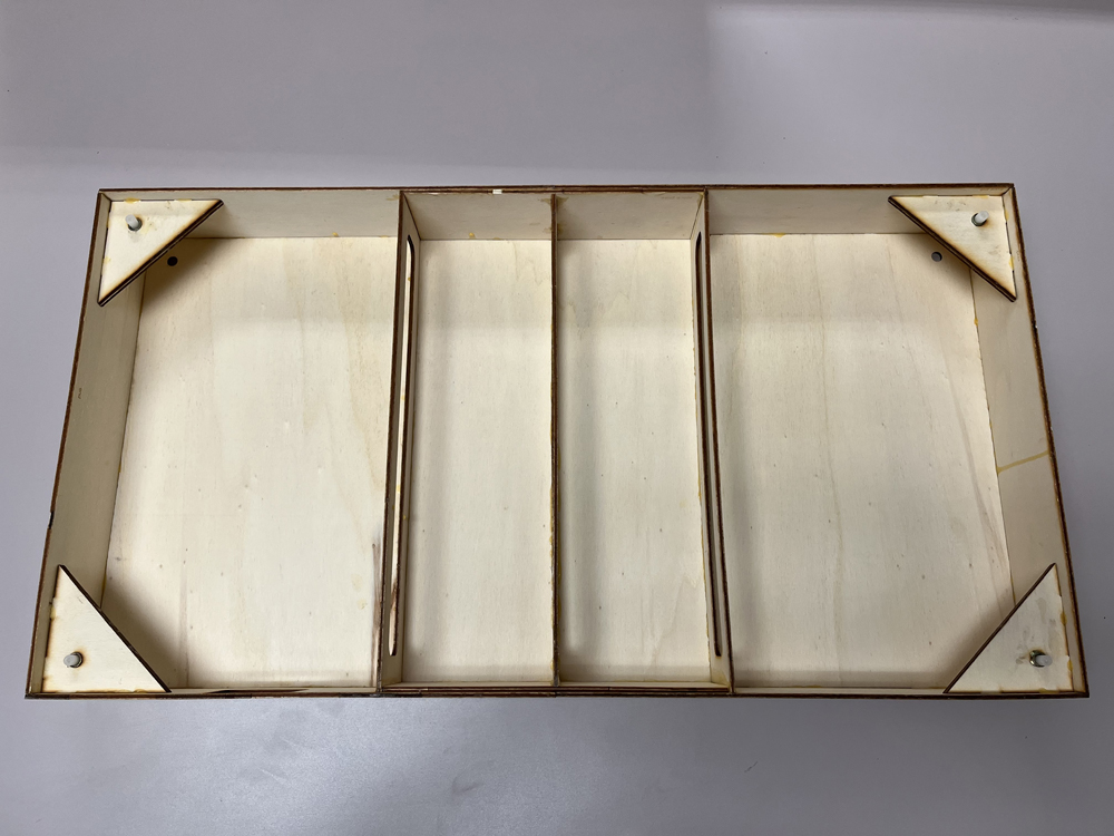 Bare wood box flipped upside down to show construction and support pieces.