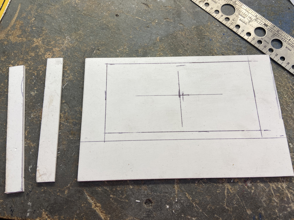 A sheet of styrene with measurements and markings on it