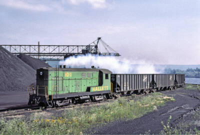 Green diesel locomotive with hopper cars
