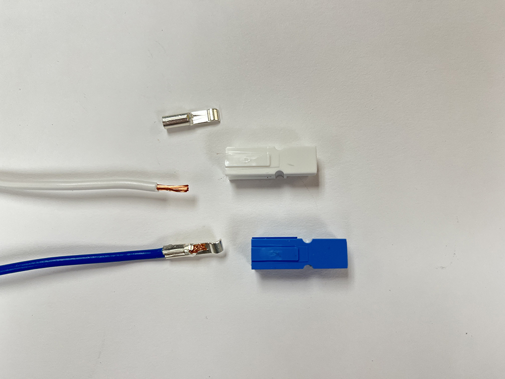 Blue and white wires with bright metal tips and white and blue rectangular plugs on white background.