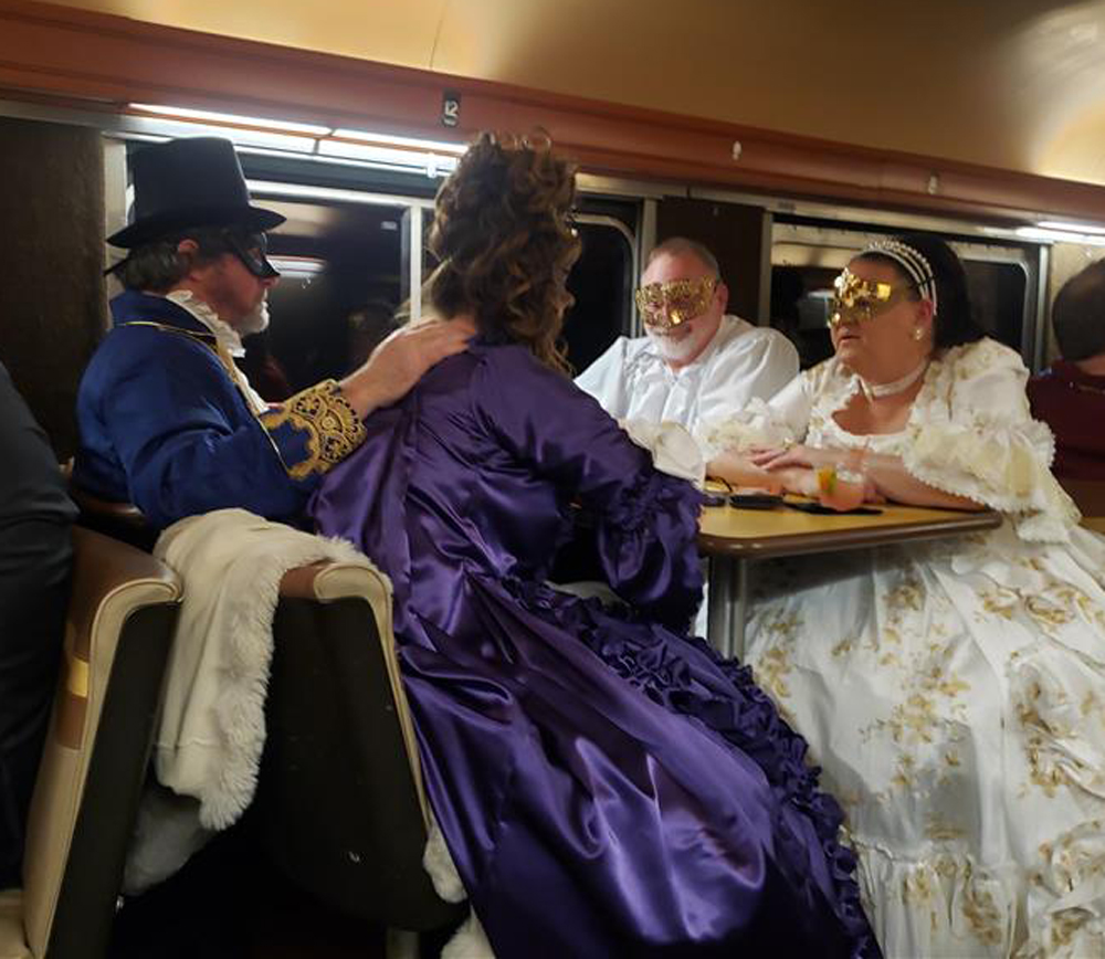 four people dressed up on train