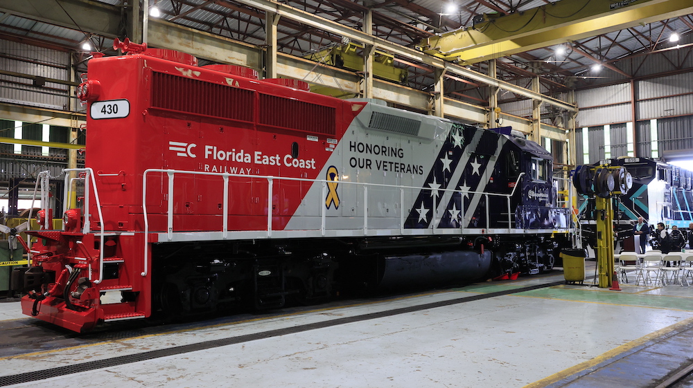 Two locomotives sit nose-to-nose in a shop.