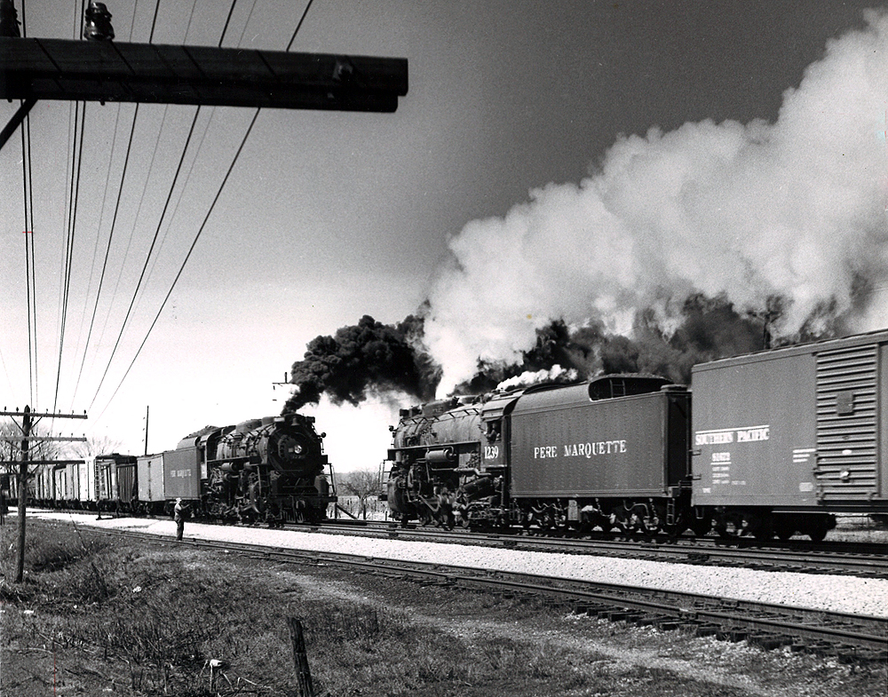 Two Pere Marquette Berkshire steam locomotives meet with freight trains