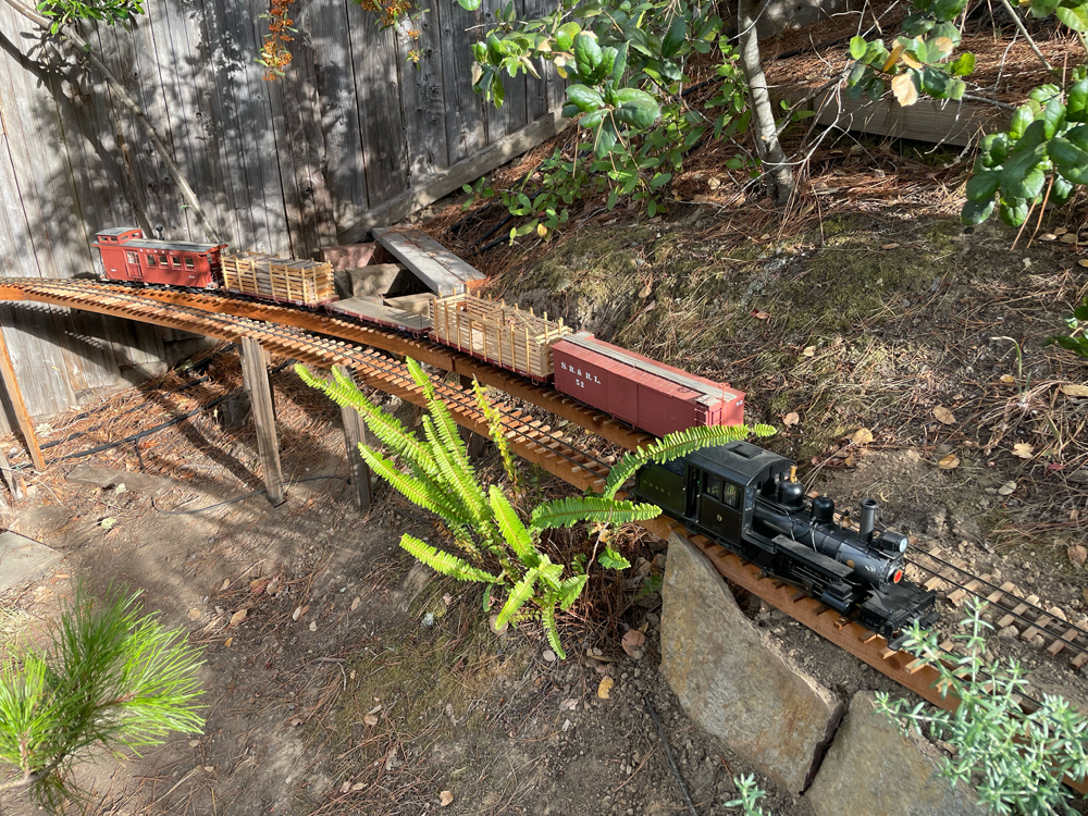 locomotive on trestle with greenery on garden railway