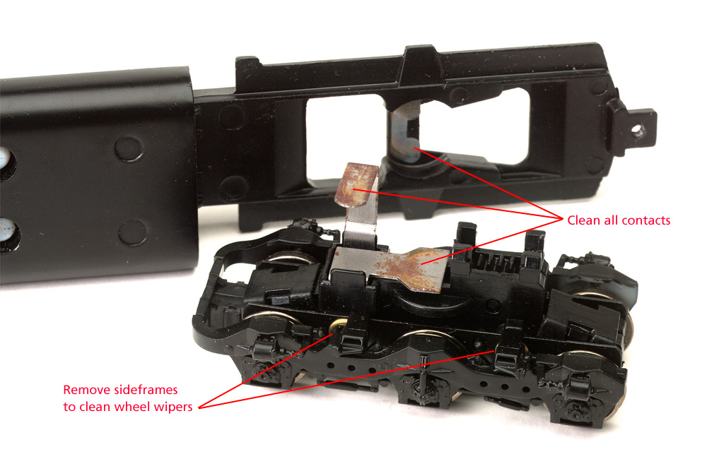 A disassembled model locomotive truck with corroded contacts